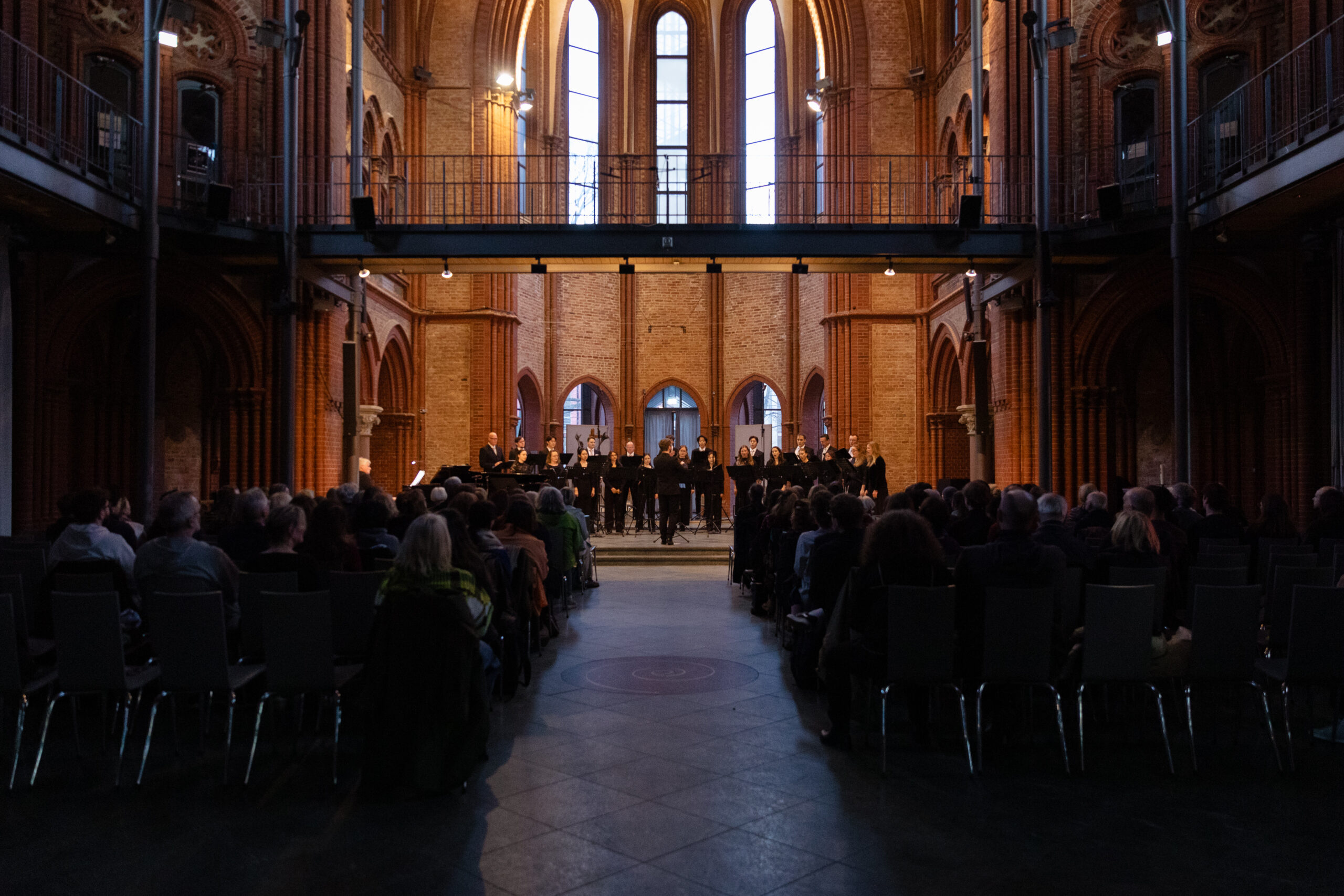 Teilnehmende der Schola des Rundfunkchores Berlin mit Sänger:innen des Rundfunkchores Berlin bei einem A-cappella-Konzert in der Heilig-Kreuz-Kirche